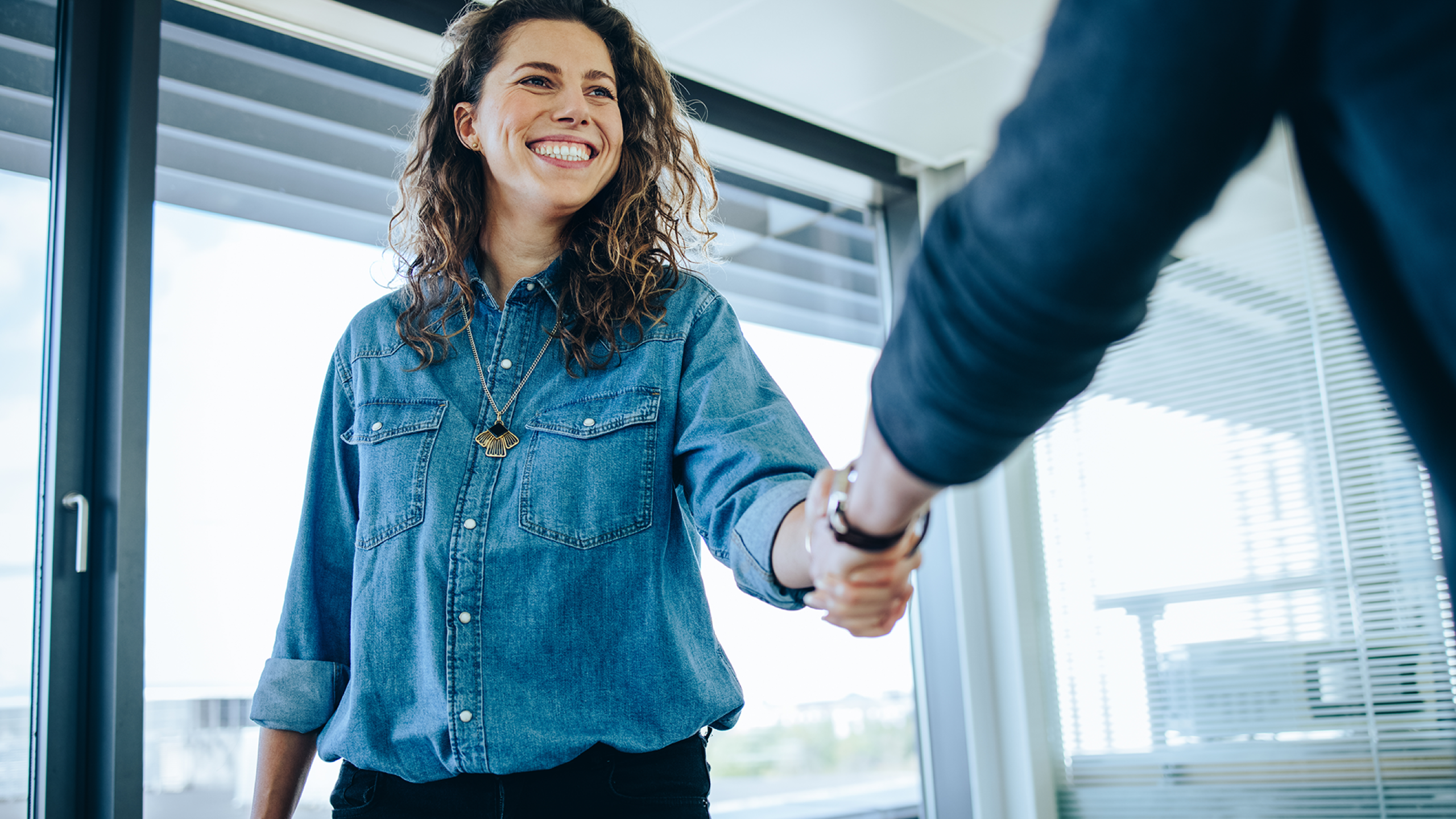 Jonge vrouw schudt HR-manager de hand