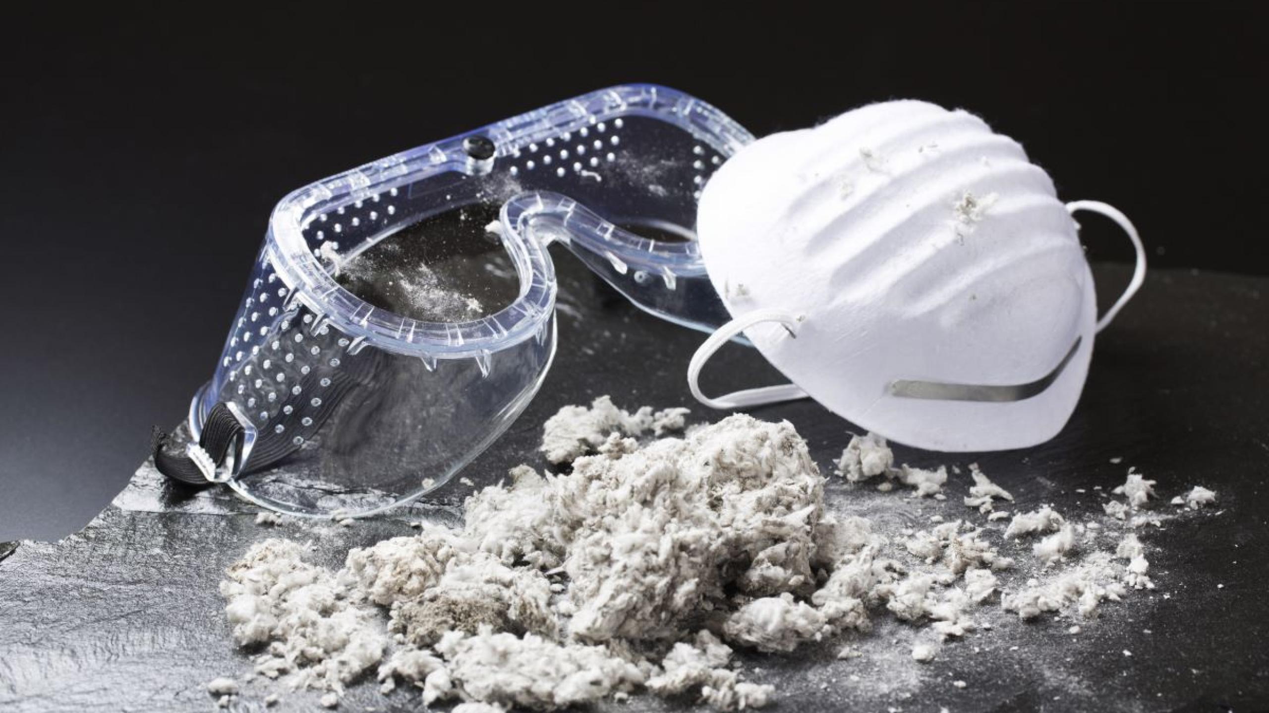 Veiligheidsbril en mondmasker naast vezelachtig materiaal (asbest)
