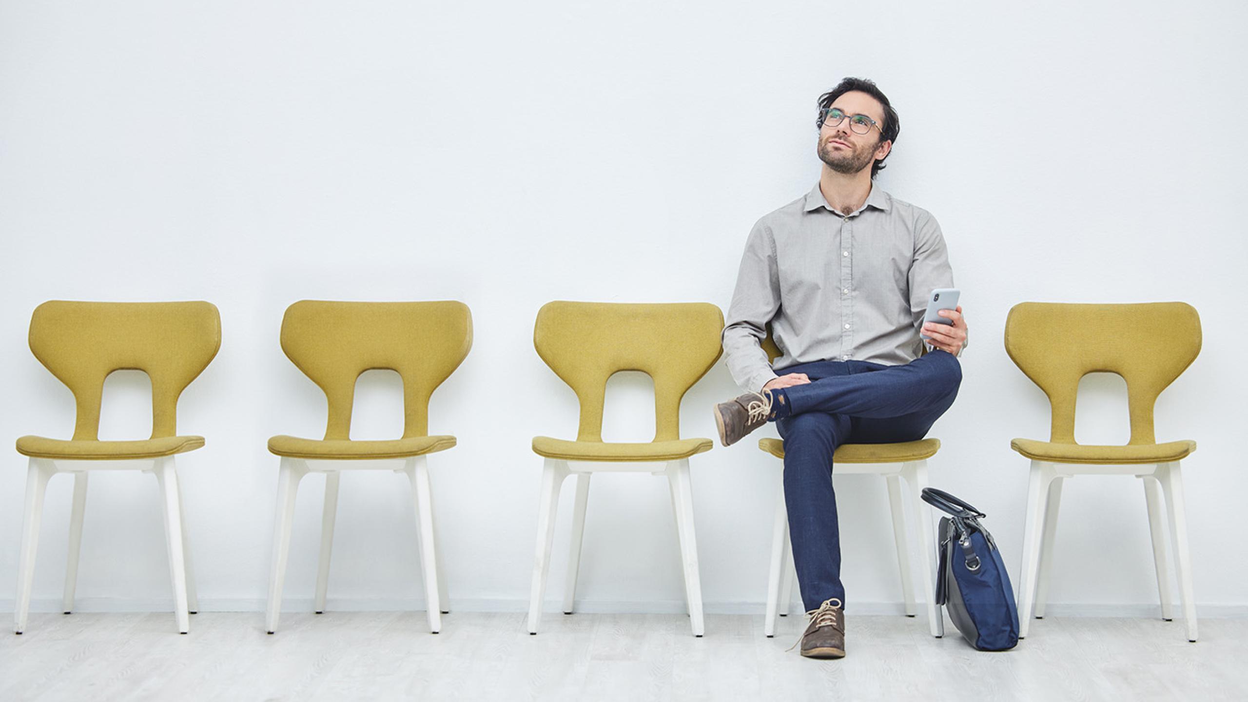 Eenzame sollicitant met een rij lege stoelen.