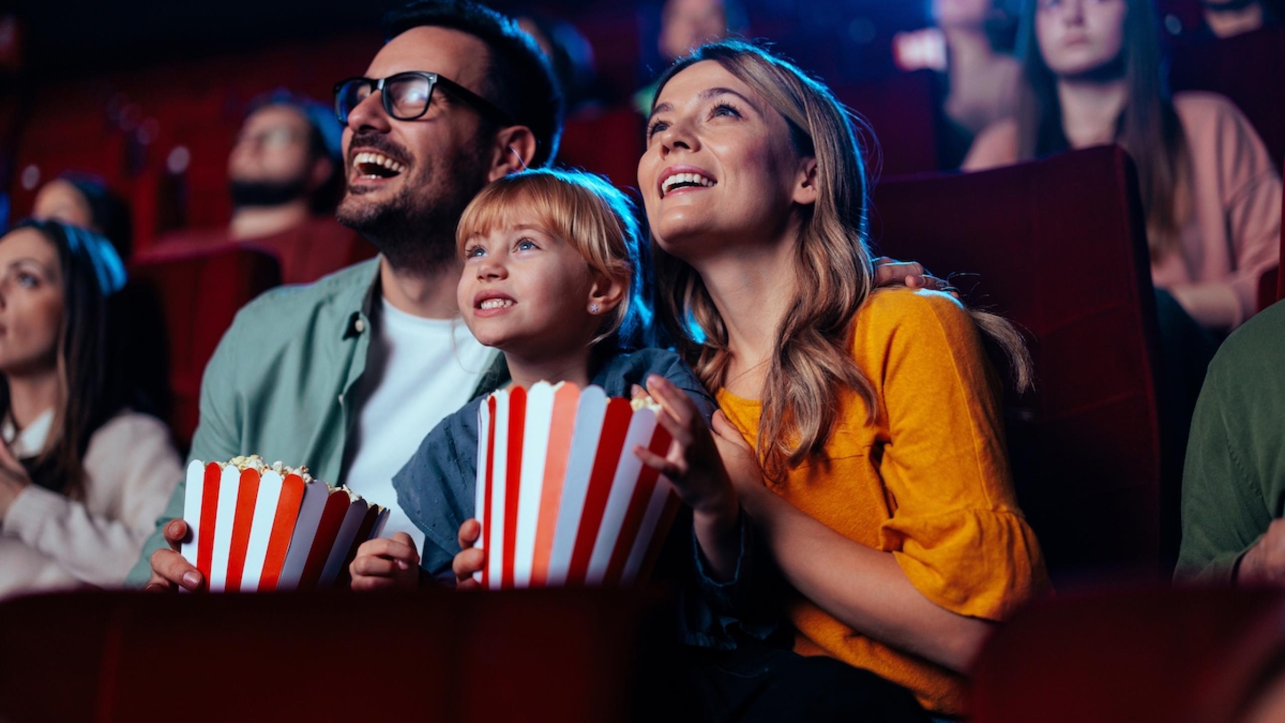 Gezin met kind en popcorn in de cinema.
