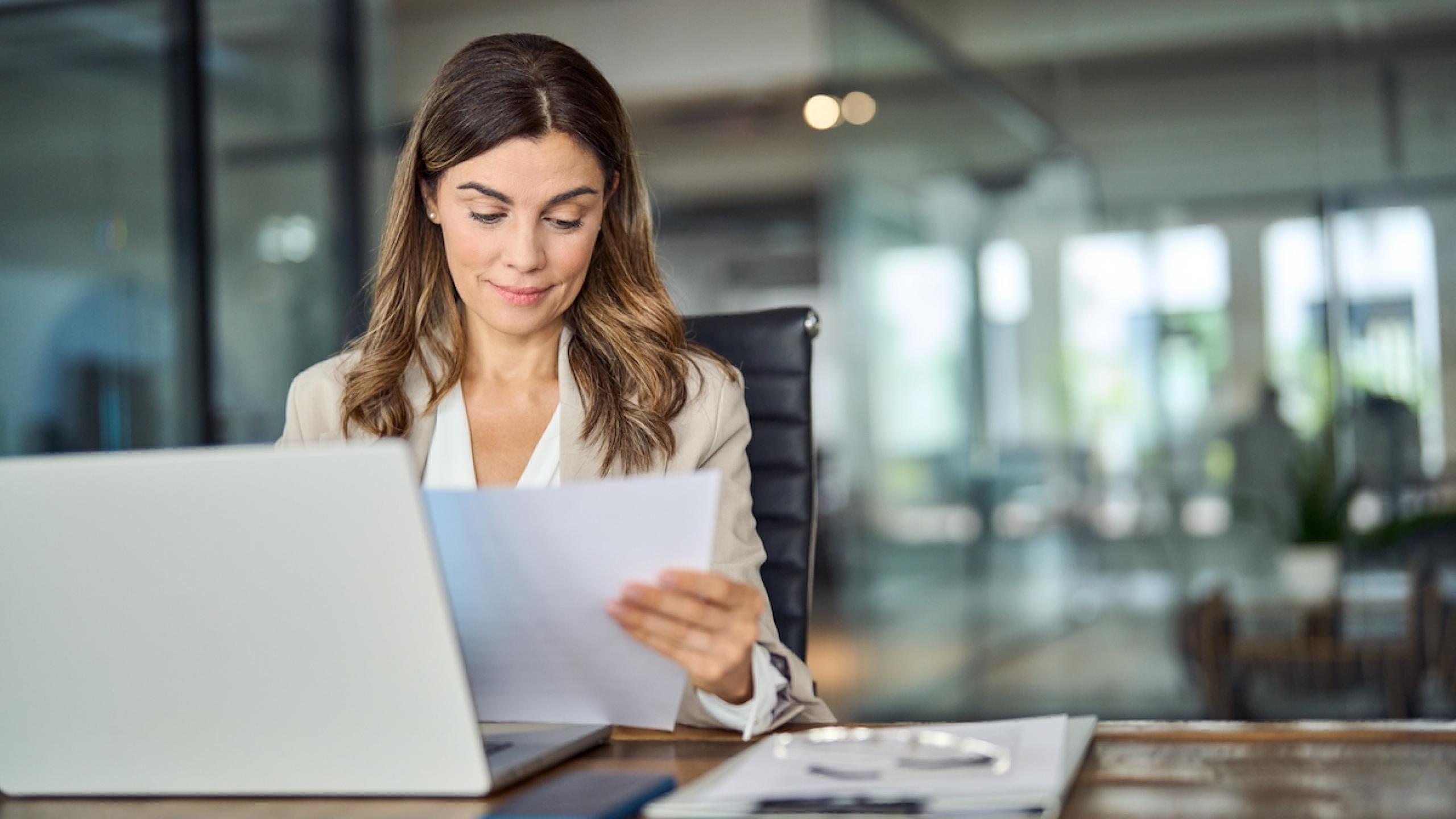 Manager leest brief aan bureau.